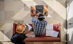 overhead view of student using laptop in lounge